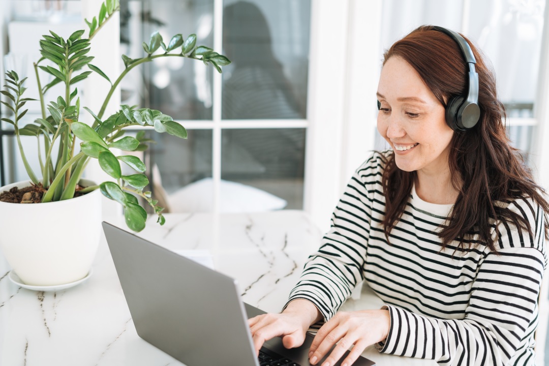 Woman enjoying benefits of transcription on laptop