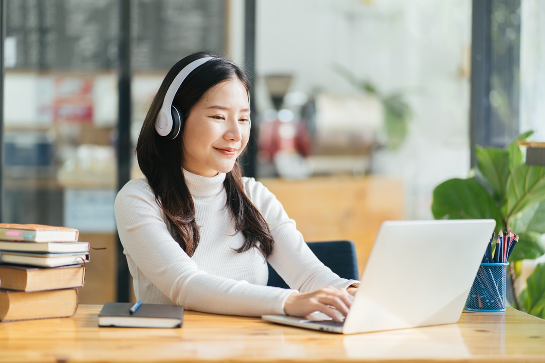 Woman learning how to write an interview transcript on laptop