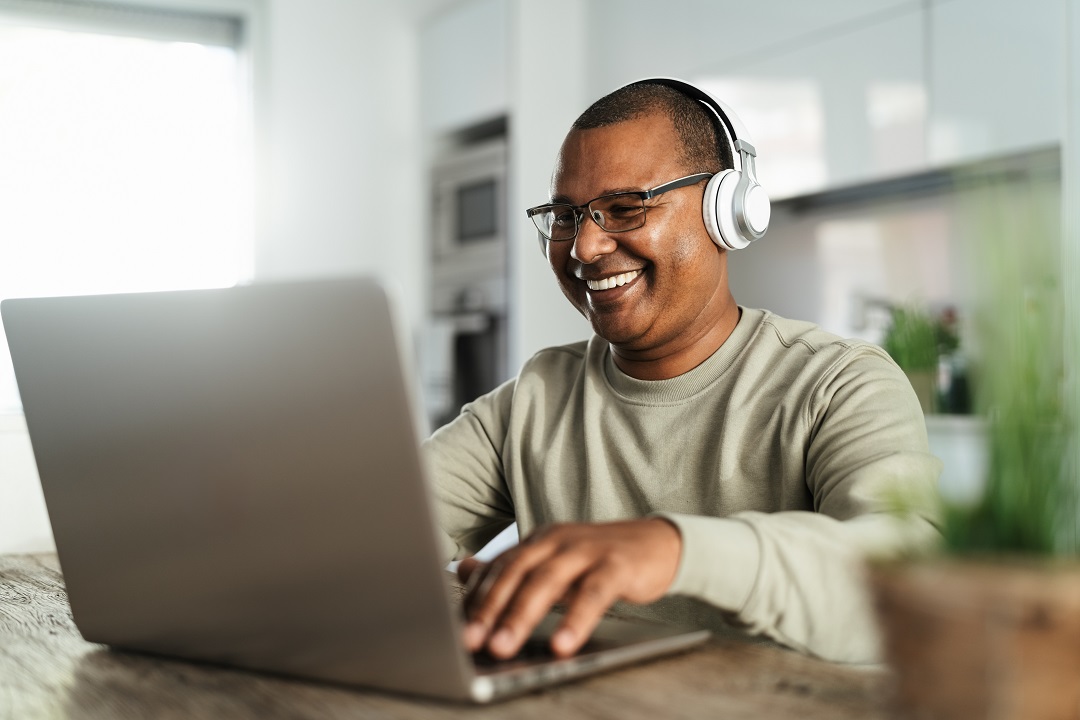Excited man creating closed captions on laptop in 2024